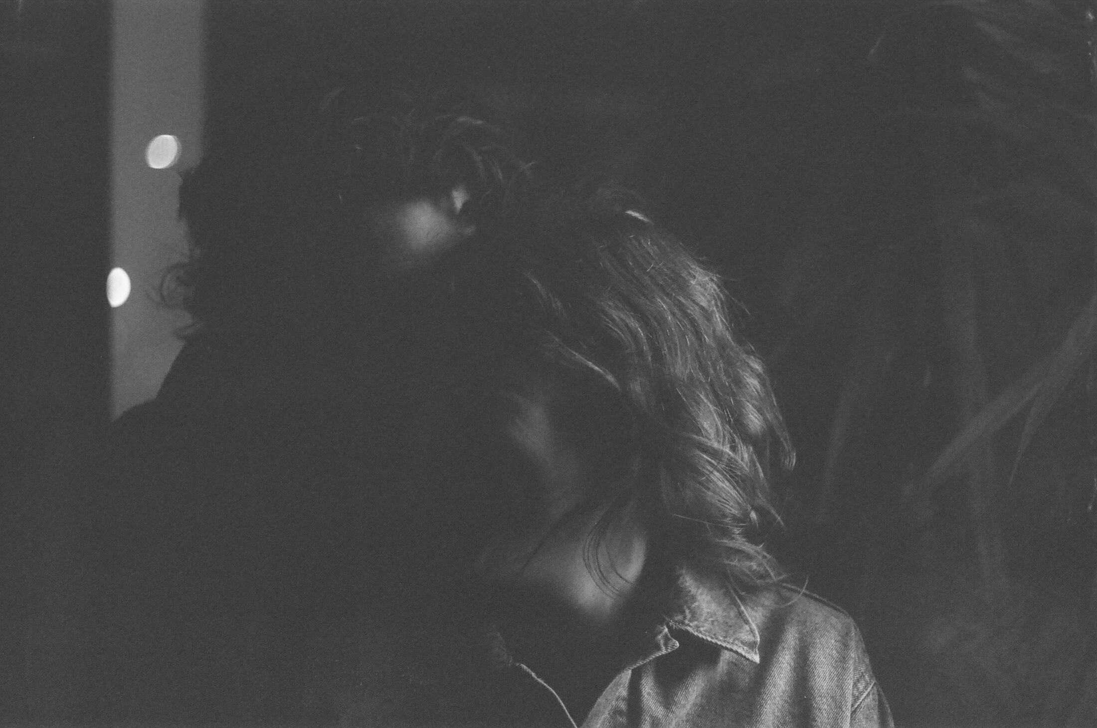 Chris and MK, heads close together in low light